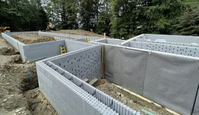 ICF foundation walls being built on a construction site with reinforced insulated concrete forms and excavation work in progress.